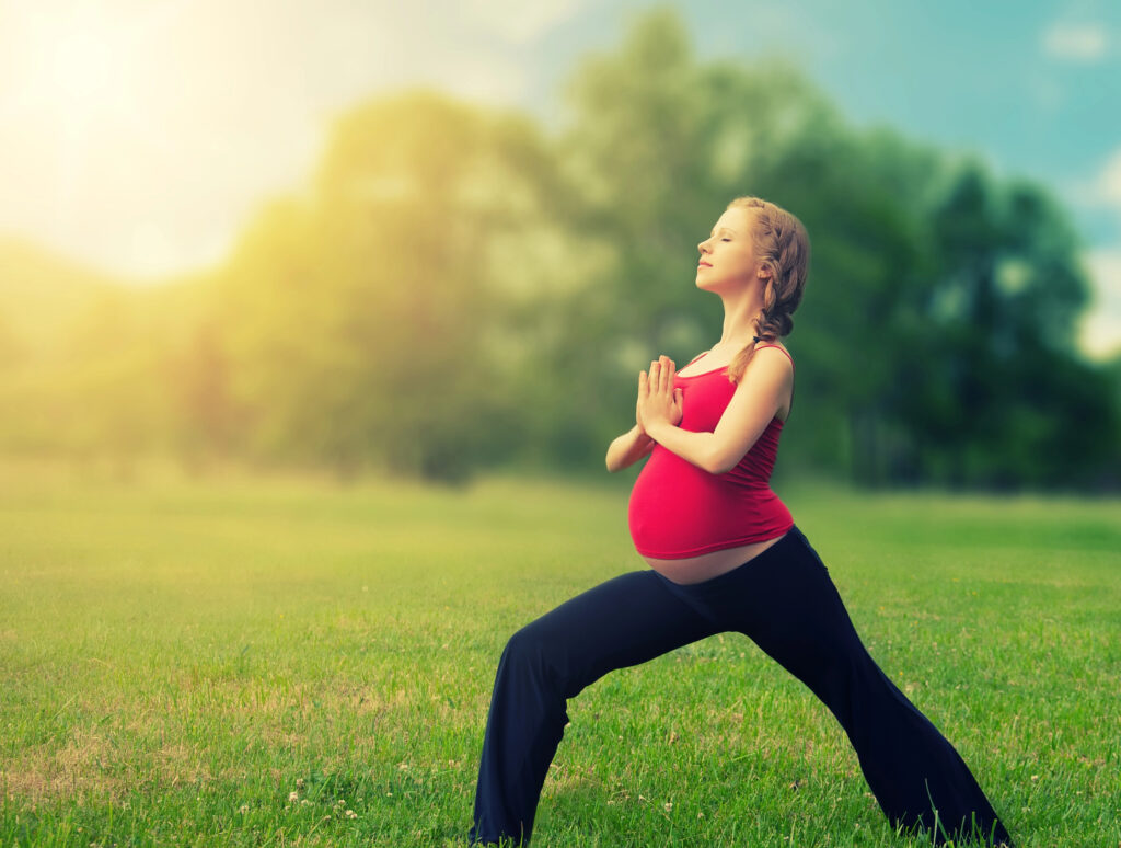Healthy pregnant woman doing yoga in nature