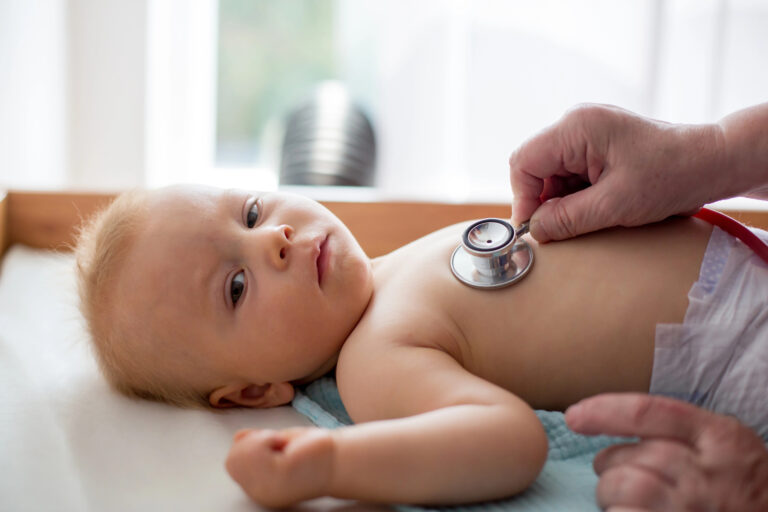 Little baby boy, toddler child having his monthly check up by pediatritian, patient being examined with stethoscope
