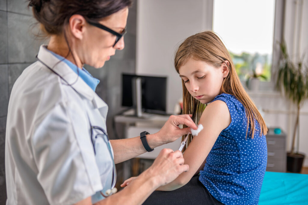 Pediatric giving vaccine shot in arm