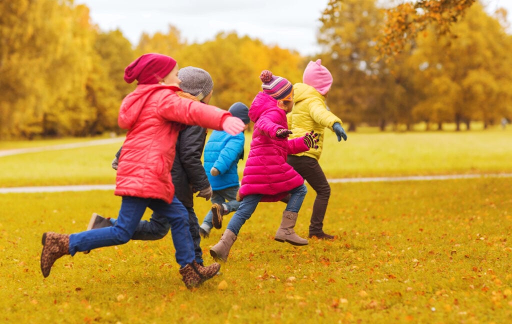 group of happy little kids running outdoors
