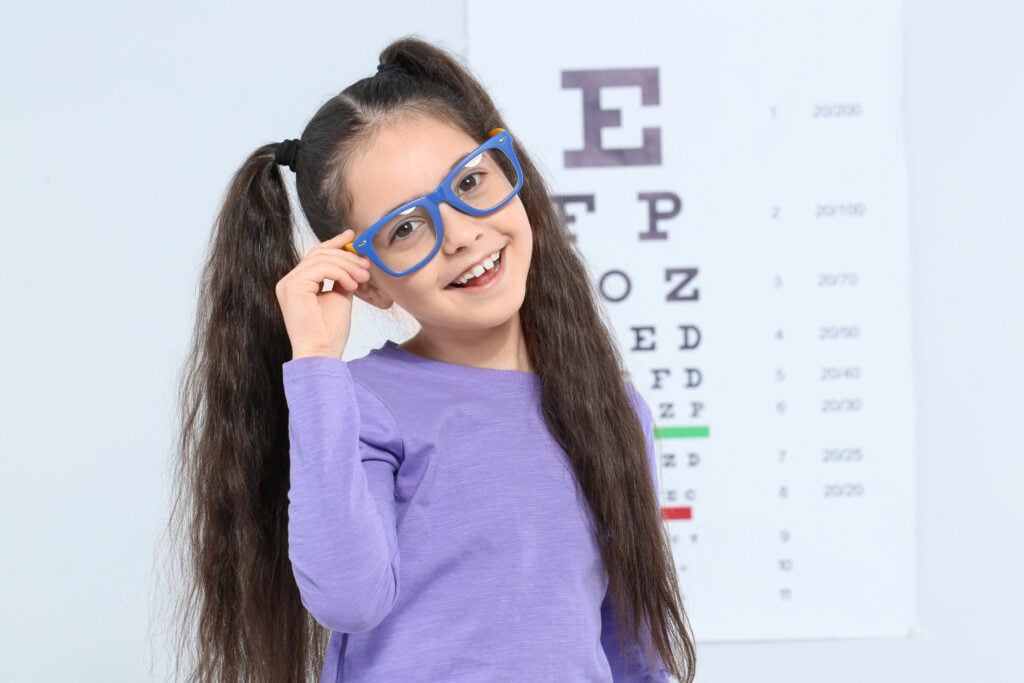 Girl wearing glasses by an eye chart