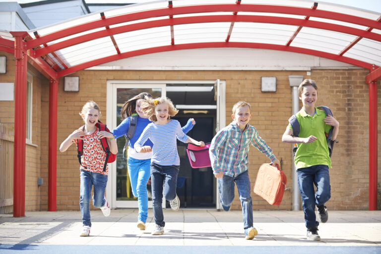 Schoolchildren Running Into Playground At End Of Class