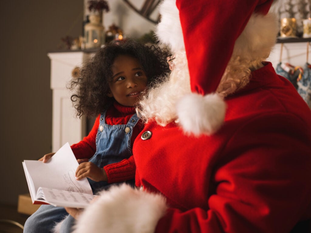 Little girl shows Santa her list