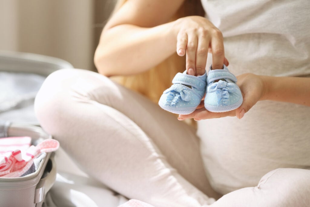 Pregnant woman packing suitcase
