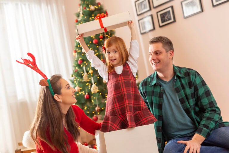Parents with child in gift box at Christmas