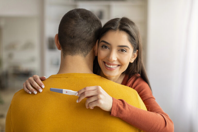 Couple is happy hugging with pregnancy test