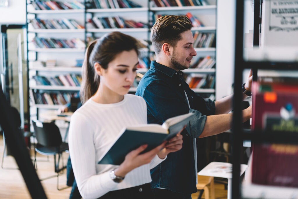 College-aged adults are studying books in a university library